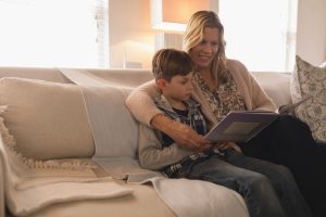 Parent lisant un livre en français avec son enfant à la maison